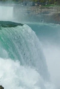 The water rushes over the edge of the falls.